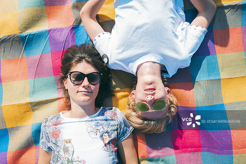 一位成年妇女和她的儿子在彩色垫子上休息图片素材