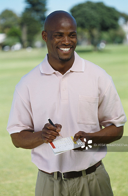 一个拿着高尔夫记分卡的年轻人的肖像图片素材