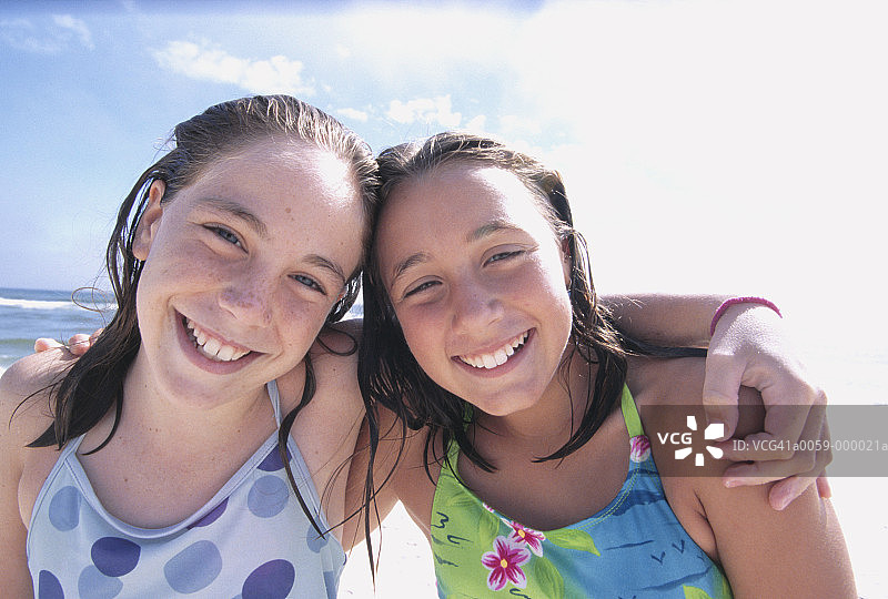 沙滩上的两个微笑的女孩图片素材