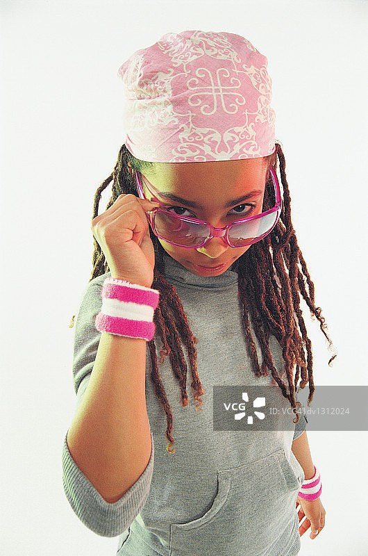 一个年轻女孩的肖像穿着汗带和头巾，凝视太阳镜图片素材