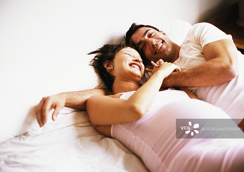 男人和孕妇并排躺在床上图片素材