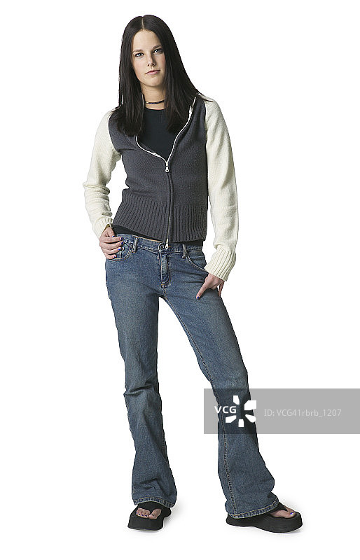 一个穿着牛仔裤和灰白色毛衣的白人少女站着图片素材