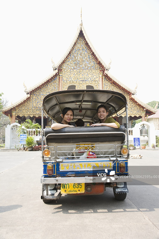 泰国，清迈，佛塔寺，两个年轻的妇女坐在巴士的后面望着外面图片素材