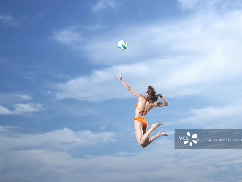 一名年轻女子在空中击打排球图片素材