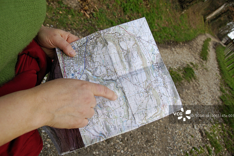 乡村公路上的女人用手指着地图，中段图片素材