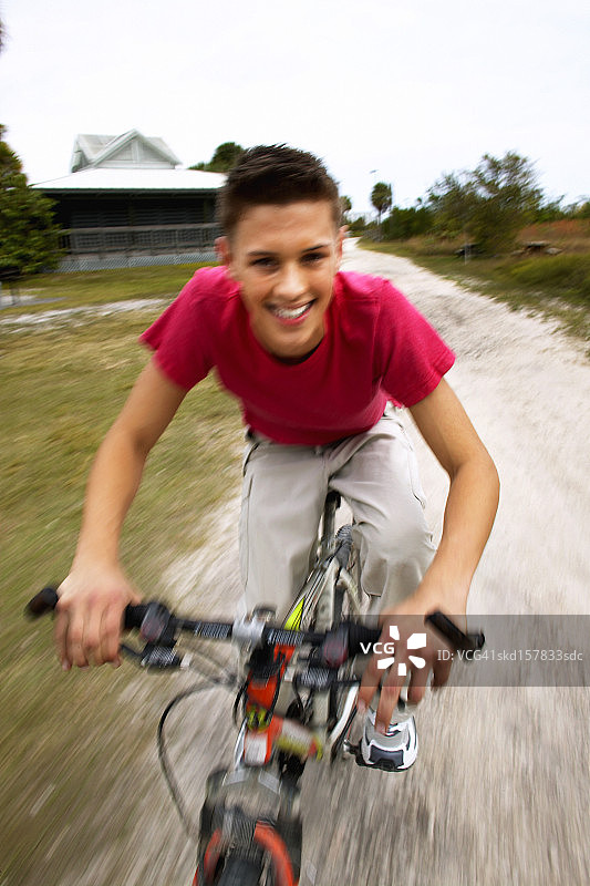 一个十几岁的男孩(16-18)骑自行车的特写肖像图片素材
