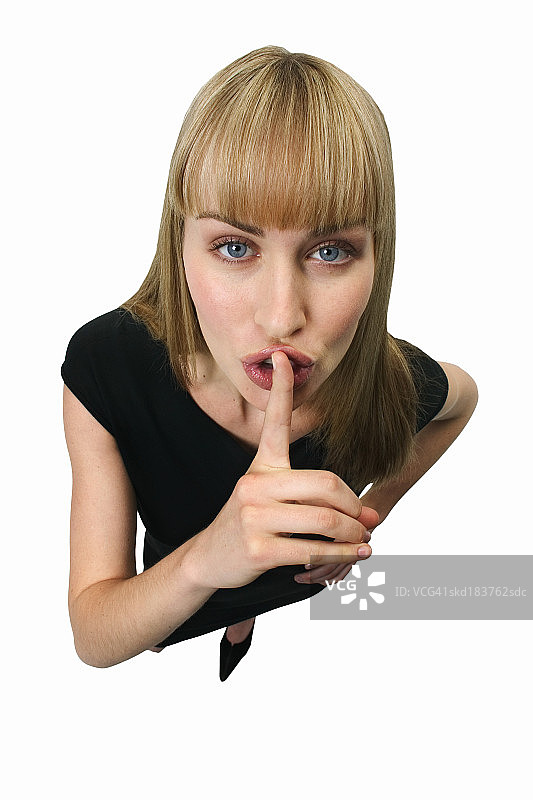 年轻女子手指放在嘴唇上的高姿态画面图片素材