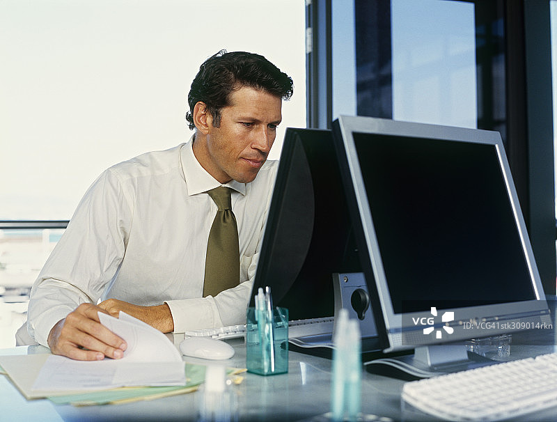 一个坐在办公室电脑前的商人图片素材