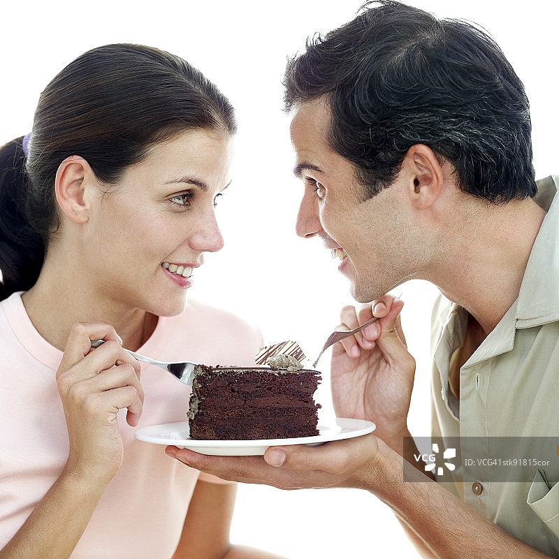 年轻夫妇分享一块巧克力蛋糕图片素材