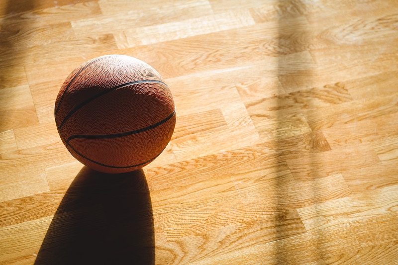 高角度的篮球在球场的硬木地板上图片下载