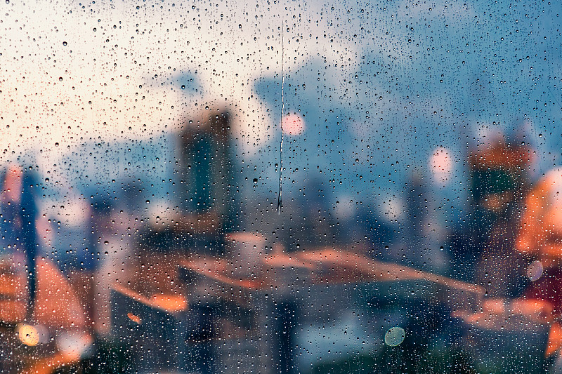 雨中的玻璃幕墙与城市天际线背景图片下载
