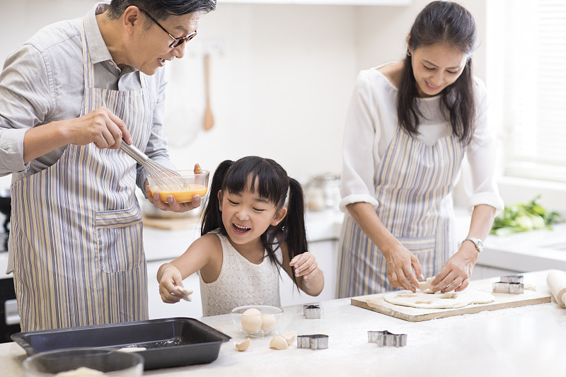 快乐小女孩和爷爷奶奶在厨房制作饼干图片下载