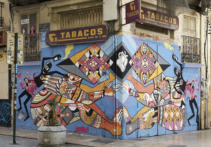 由色彩鲜艳的装饰物组成的人物连在一起，由瓦伦西亚街头艺术艺术家disney ylexya绘制的墙壁，西班牙瓦伦西亚的老城El Carme图片下载