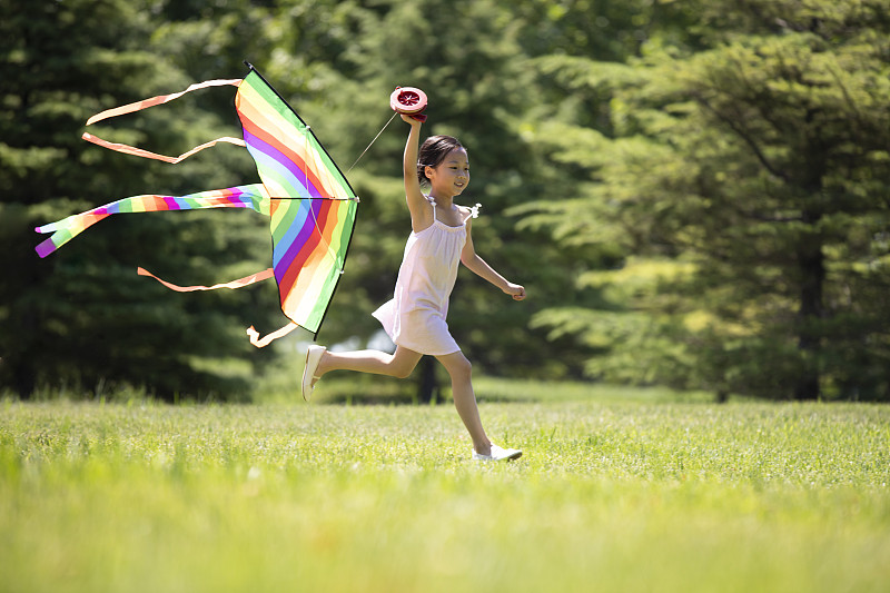 快乐的小女孩在草地上放风筝图片下载