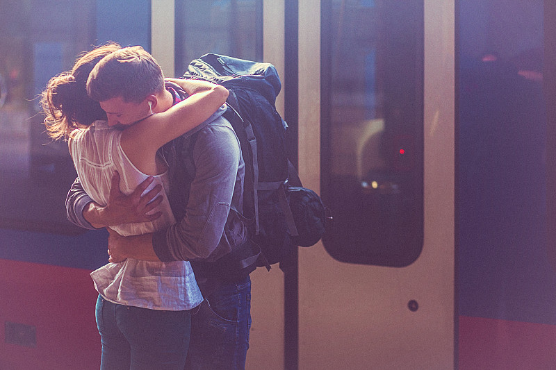 女人和男人在火车站月台拥抱的肖像图片下载