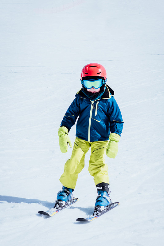 小男孩穿着滑雪服学习滑雪图片下载