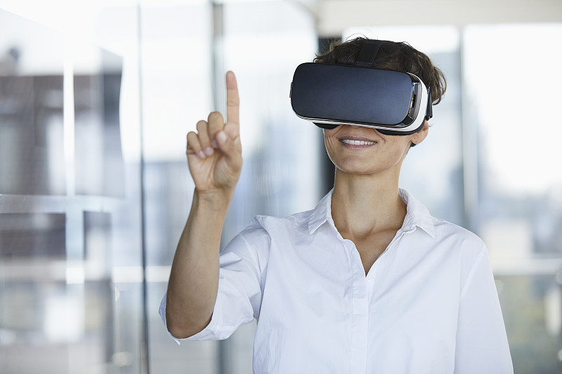 女商人戴着虚拟现实眼镜在办公室举起手指图片下载