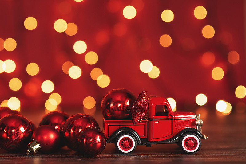 2019年7月31日，俄罗斯亚速。一辆红色的汽车载着一棵圣诞冷杉树在雪地的背景下。圣诞和寒假的概念。副本的空间。图片下载