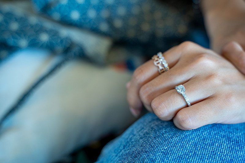 女人手指上戴着钻石戒指。图片素材