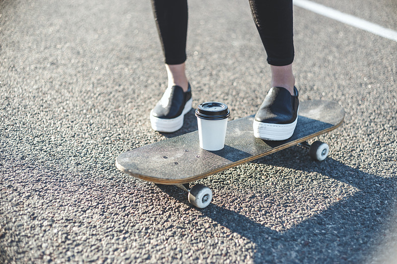 在公路上滑滑板的女人的低段图片素材