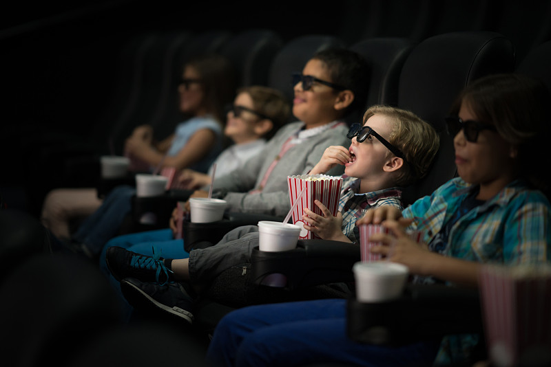 孩子们戴着3D眼镜在电影院看电影图片素材