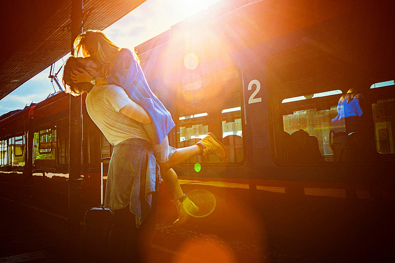年轻男女在火车站月台拥抱的肖像图片素材