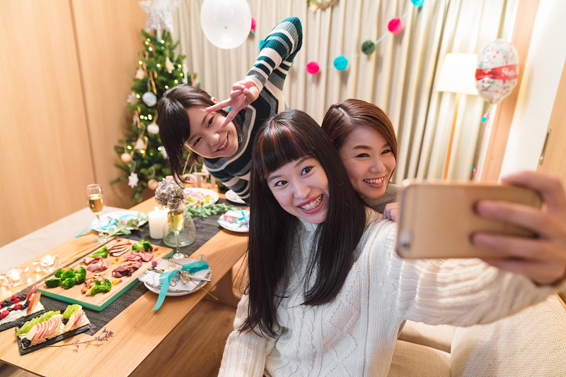 三个年轻的女性朋友庆祝圣诞节和自拍图片素材
