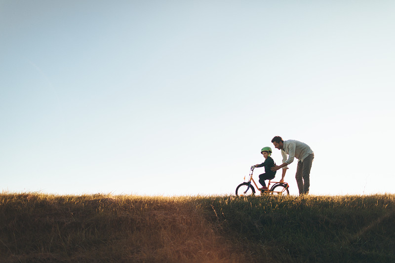 父亲和儿子在自行车道上图片素材