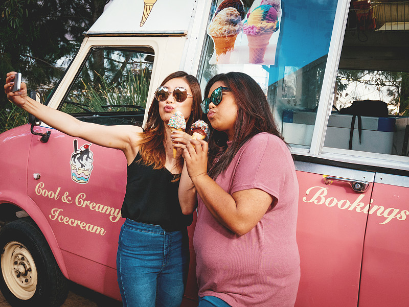 两个朋友在冰淇淋车上吃冰淇淋图片下载