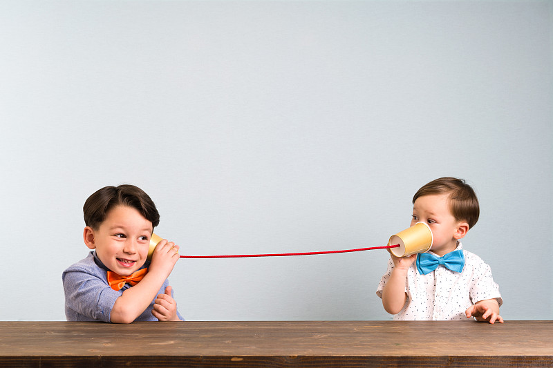 两个孩子正在用纸杯当电话图片下载