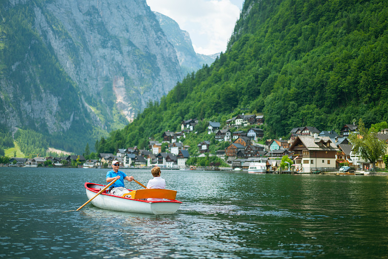 活跃的老夫妇与划船在山湖图片下载