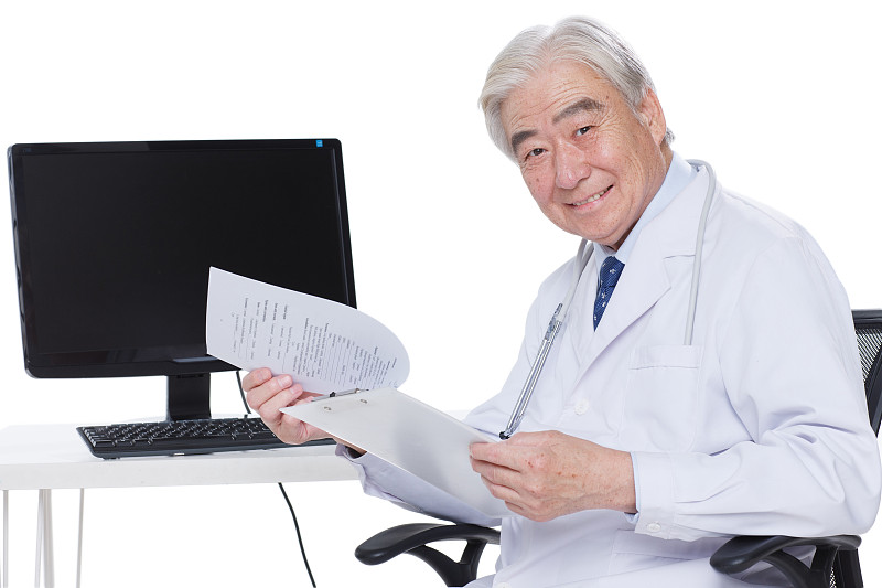 一个老年医生在看病历卡图片素材