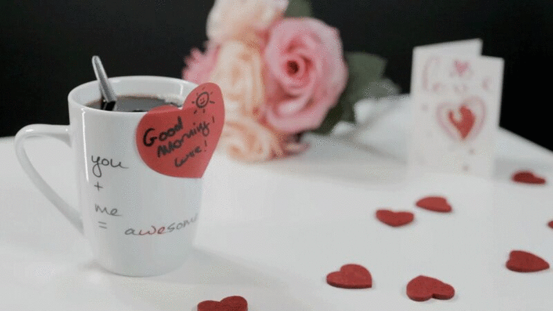 一杯有心形贴纸的咖啡，桌上有心和花图片下载