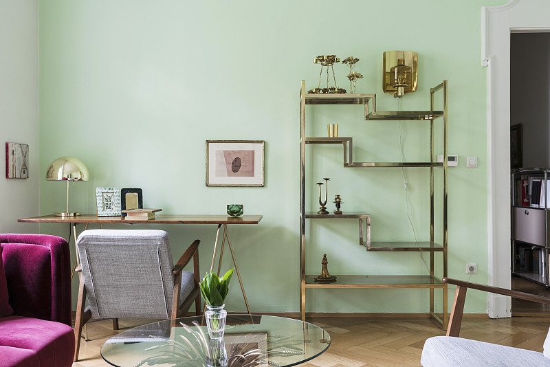 客厅的黄铜架子和精致的桌子，绿色的墙壁图片下载