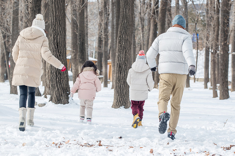 欢乐家庭在雪地里奔跑图片素材