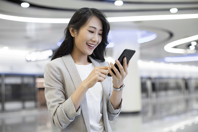 年轻商务女士在机场使用手机图片素材
