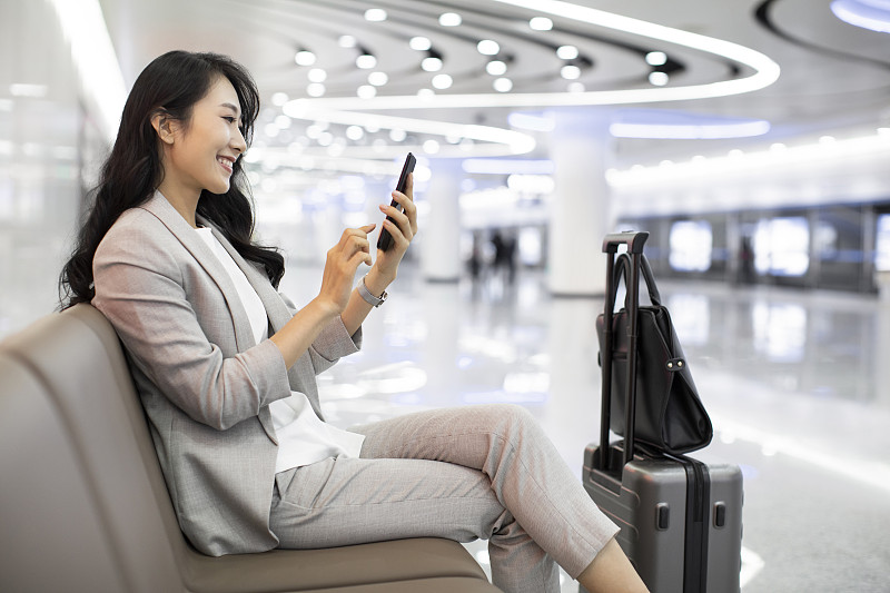 年轻商务女士在机场使用手机图片下载