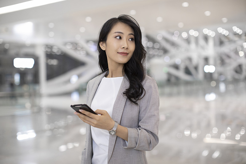 年轻商务女士在机场使用手机图片下载