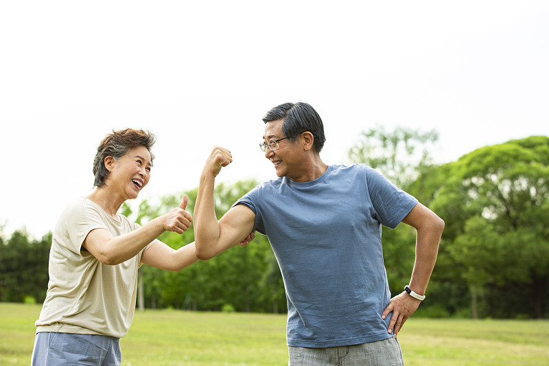 老年男人展示肌肉和老年女人点赞在户外公园运动后图片下载