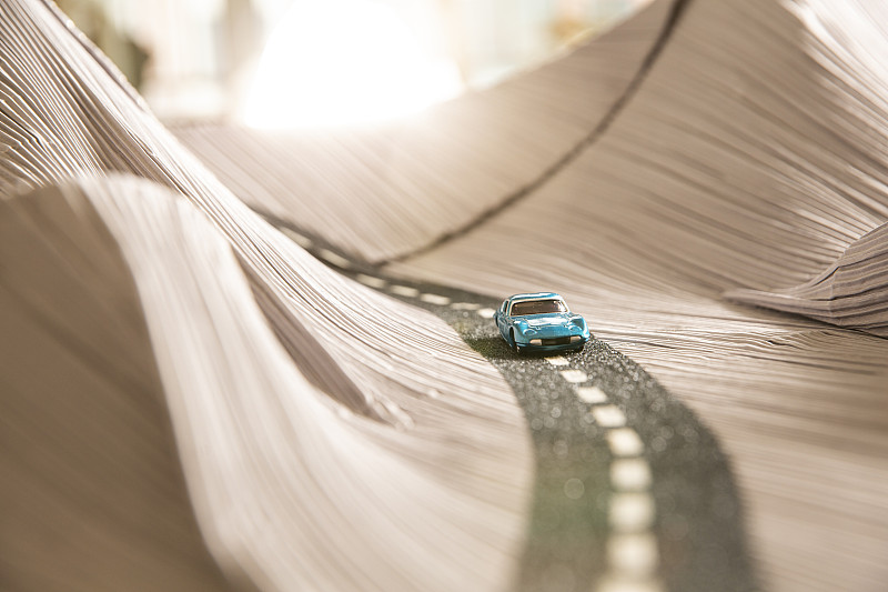 夕阳下玩具汽车和沙漠沙丘公路创意微景观静物图片素材
