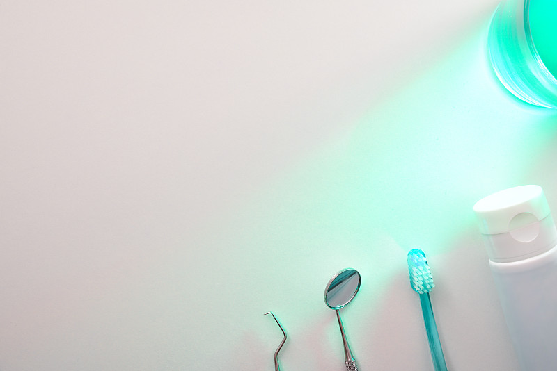 高角度的牙医工具和漱口水在桌子上绿色的光顶部图片下载