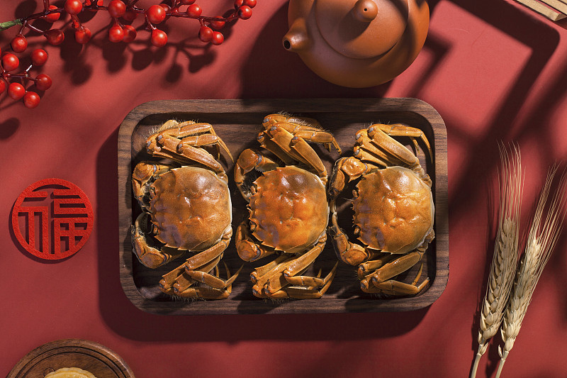 盛放在木盘里的三只美味的大闸蟹图片素材