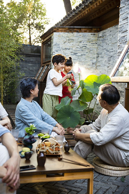 中秋节一家六口在户外庭院聚餐嬉戏玩耍图片素材