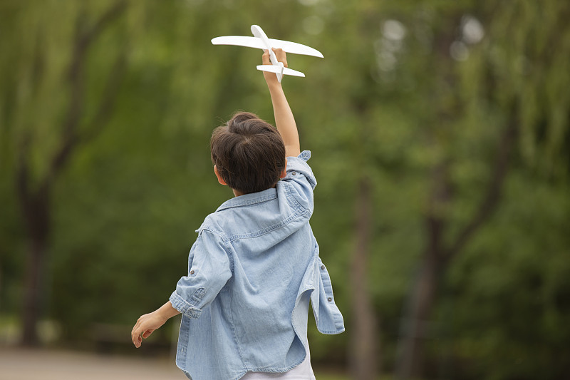 小男孩在公园玩飞机模型图片素材