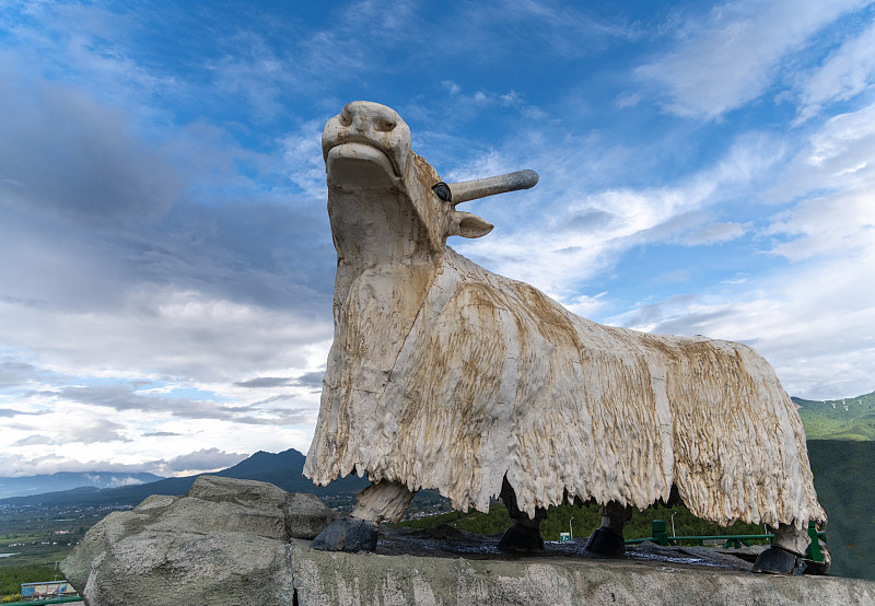 中国云南蓝天白云为背景的牦牛雕塑图片素材