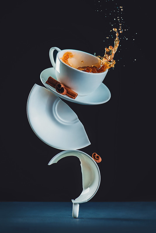 特写咖啡倒在杯子对黑色背景抽象概念图片下载