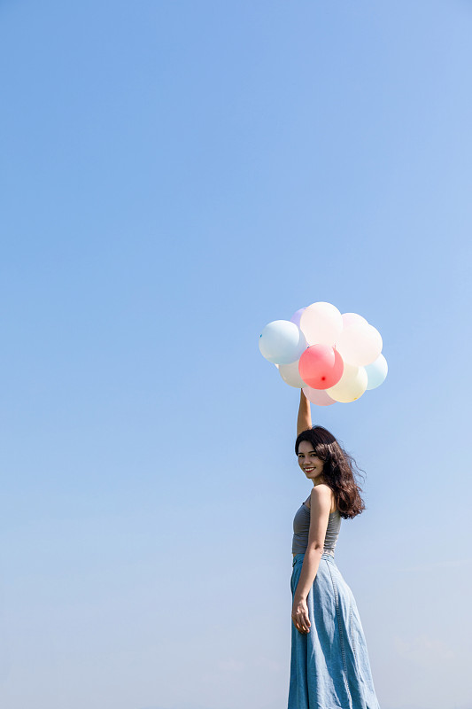 蓝天白云下一名中国女生在玩气球图片下载