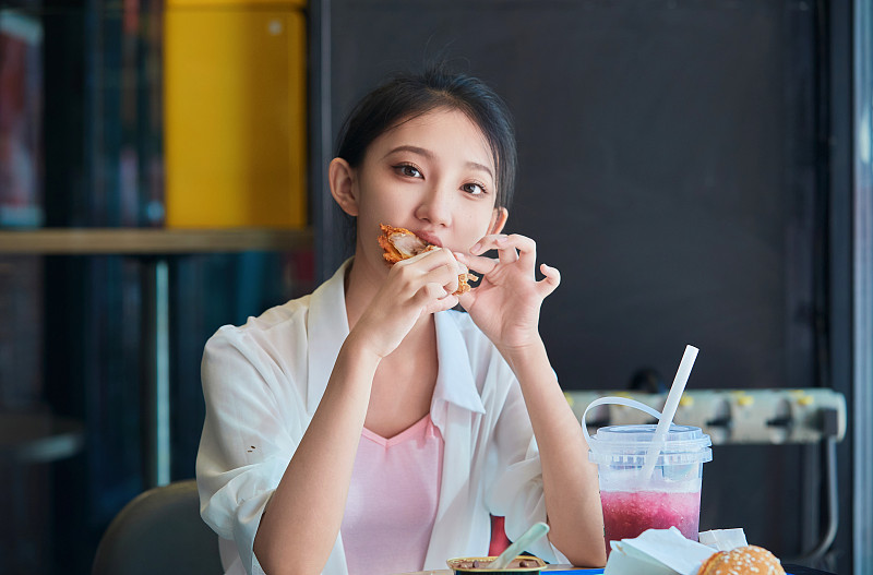 在商场快餐厅大吃特吃的中国可爱少女人像图片下载