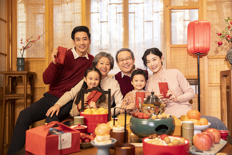 东方家庭过年：幸福一家人在客厅拜年、送红包图片下载