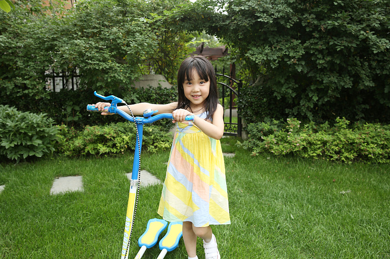 快乐的小女孩骑滑板车图片下载